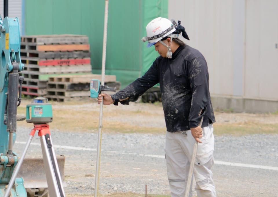 計測器具を持つ土木職人7年目の中山さん